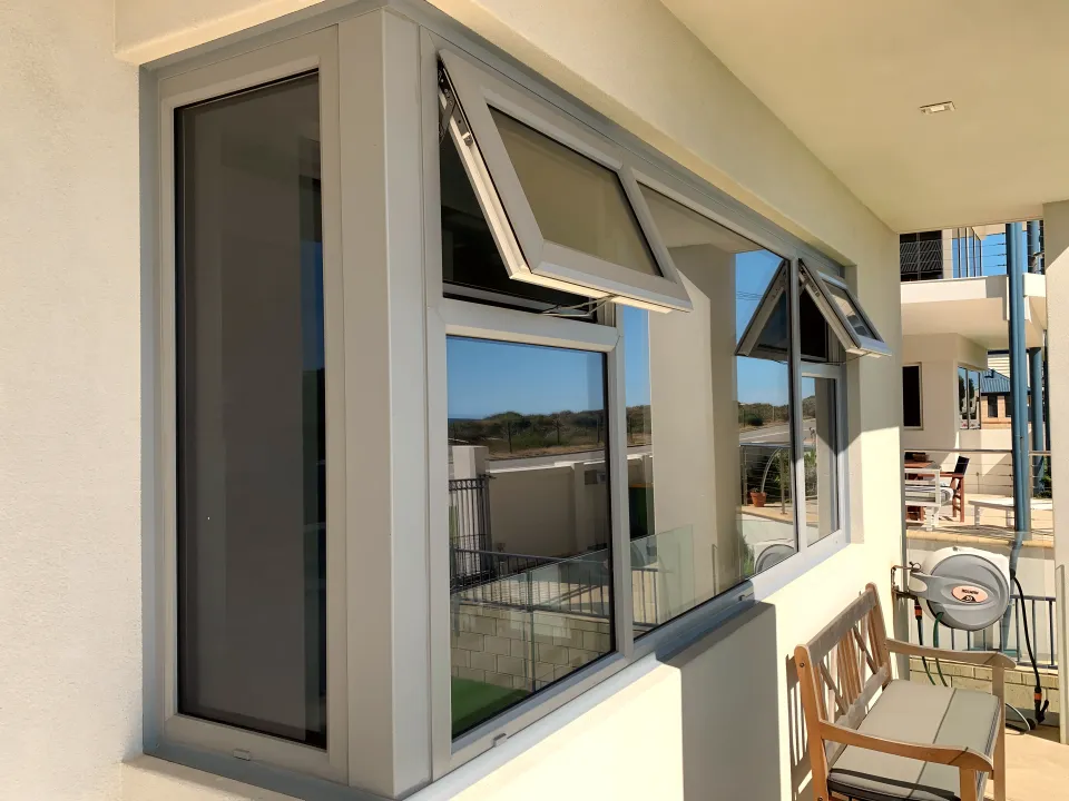Bay of awning window sashes propped open on a balcony