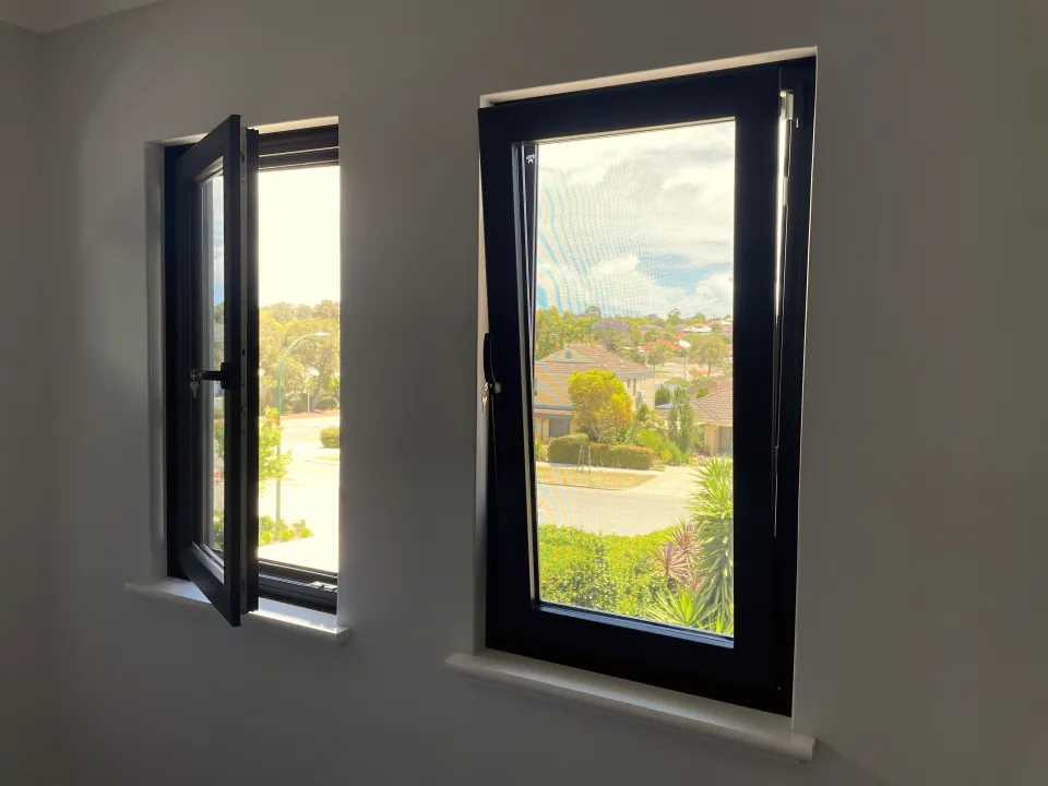 Anthracite tilt-and-turn windows, one sash swung open on side hinges